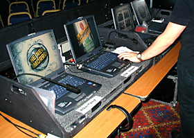 Four computers running images and presentation on separate central and side screens, and monitors